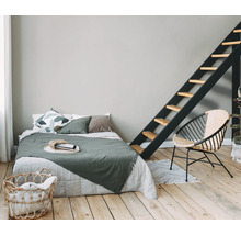 Schlafzimmer mit Bett, Leiter, Korbsessel und Wäschekorb