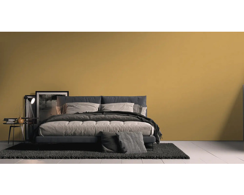 Schlafzimmer mit Bett, Nachttisch und Teppich vor einer Wand