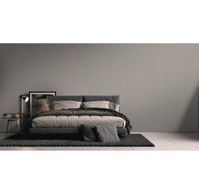 Schlafzimmer mit Bett, Nachttisch, Lampe und Teppich