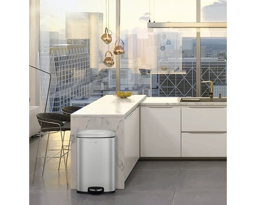Mülleimer aus Metall in einer hellen Küche mit modernen Möbeln und Blick auf eine Stadt.
