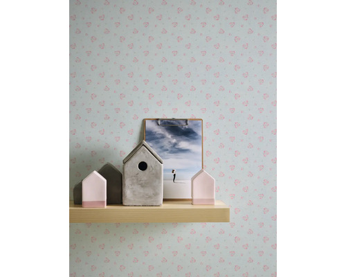 Wandgestaltung mit Mustertapete, Dekohäusern und Bild auf einer Holzablage