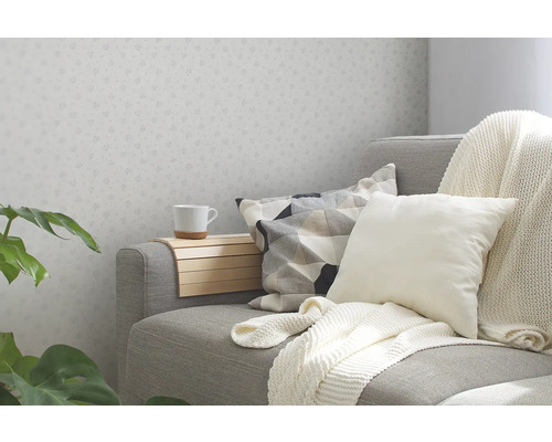 Coin salon confortable avec canapé, coussins, plaid et tablette d''accoudoir pour une tasse