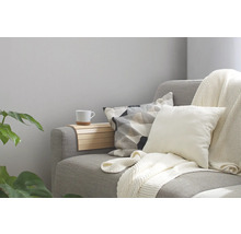 Gemütliche Sitzecke mit Sofa, Kissen, Decke und Ablage