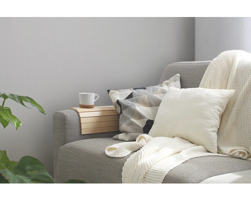 Gemütliche Sitzecke mit Sofa, Kissen, Decke und Ablage