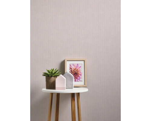 Scène décorative avec papier peint à fleurs, table, plante d''intérieur et cadre photo