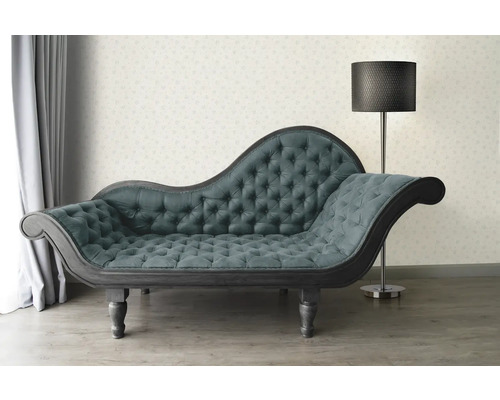 Chaise longue capitonnée et lampadaire dans une pièce lumineuse.