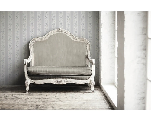 Zweisitzer Sofa im Vintage-Stil vor einer gemusterten Tapete