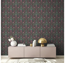 Zimmer mit dunkler floral gemusterter Tapete, Sideboard, Lampe und Dekor
