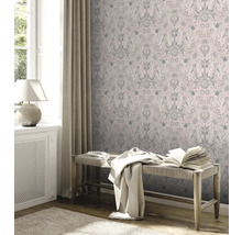 Salon décoratif avec papier peint à motifs floraux, banc et jeté de lit.