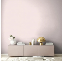 Wohnzimmer mit rosa Wand, Sideboard, Tischleuchte und Dekoration