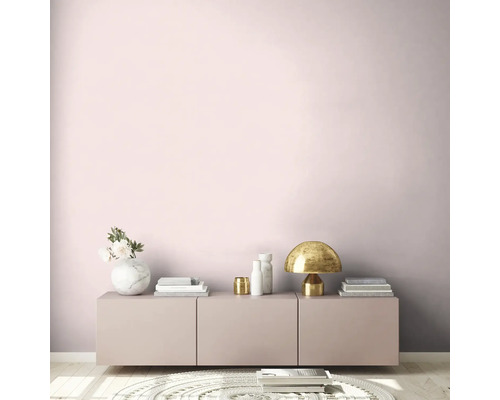 Wohnzimmer mit rosa Wand, Sideboard, Tischleuchte und Dekoration