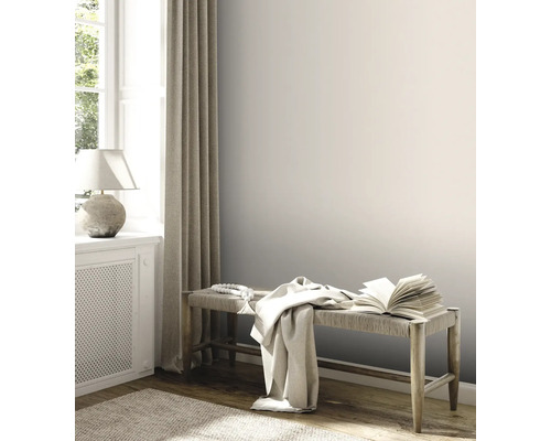 Pièce lumineuse avec banc en bois, livre et textiles