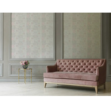 Rosa Sofa vor einer Wand mit gemusterter Tapete