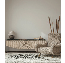 Wohnzimmer-Interieur mit gemustertem Sessel, Sideboard, Lampe und Teppich für eine gemütliche Atmosphäre.