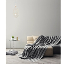 Wohnzimmer mit Sofa, Decke, Tisch und Lampe