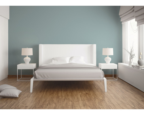 Chambre moderne avec lit double, tables de chevet et lampes sur plancher en bois.