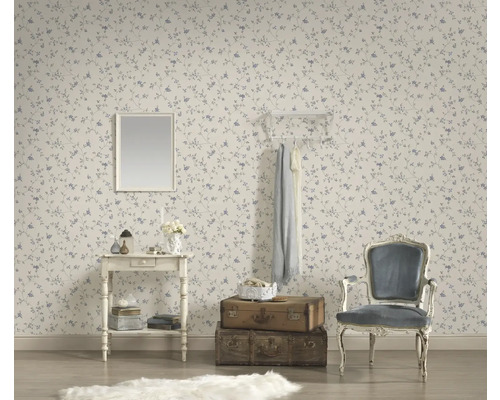 Dekoratives Zimmer mit gemusterter Tapete, Spiegel, Kommode, Kleiderhaken, Stuhl und Reisekoffern