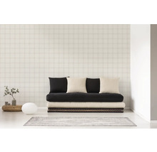 Ein Zimmer mit einer Couch, Kissen und einer Tapete mit Karomuster.