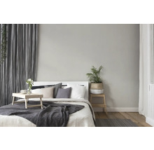 Chambre à coucher aménagée de manière claire avec lit, table de chevet, rideaux et décorations