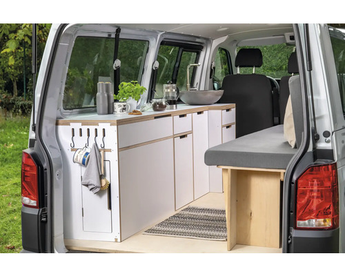 Aménagement intérieur d''un fourgon avec kitchenette, évier et lit.