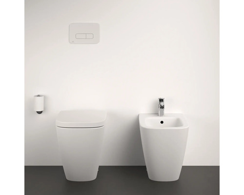 Toilettes, bidet et plaque de commande dans une salle de bains lumineuse