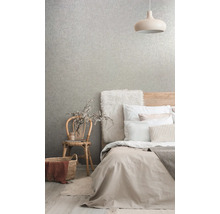 Schlafzimmer mit Bett, Lampe, Stuhl und gemusterter Tapete für ein helles und organisiertes Ambiente.
