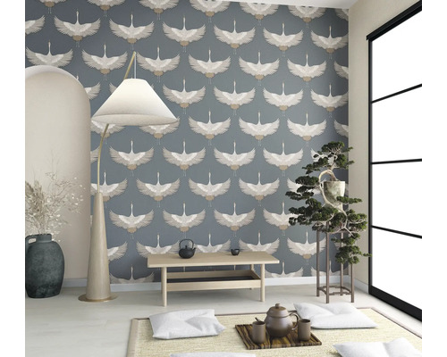 Heller Raum mit Tapete mit Vogelmuster, Stehlampe, kleinem Tisch und Zimmerpflanze.