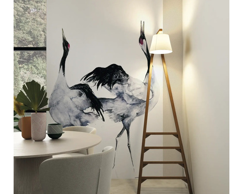 Espace de vie avec table de salle à manger, chaises, papier peint avec motif de grue et lampadaire en forme d''échelle