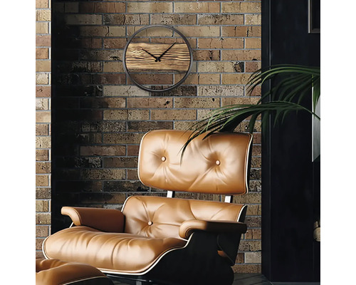Aménagement de salon avec une horloge murale avec détails en bois et un fauteuil rembourré devant un mur en briques.