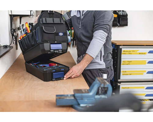Geöffnete Werkzeugtasche mit Werkzeugen auf einer Werkbank