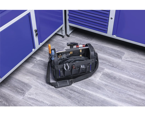 Gefüllte Werkzeugtasche mit verschiedenen Werkzeugen und blauen Werkzeugschränken