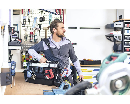Handwerker mit Werkzeugtasche in Werkstatt