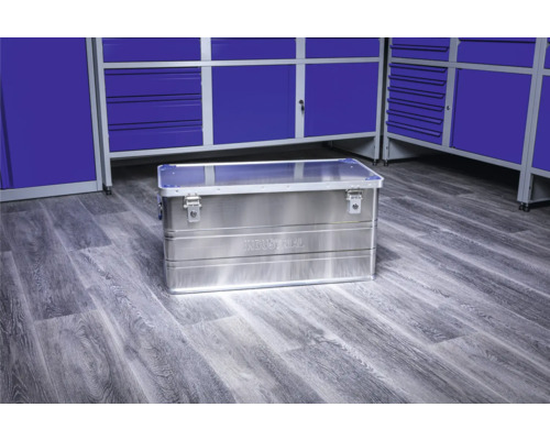 Werkzeugkiste aus Aluminium vor blauen Werkstattschränken