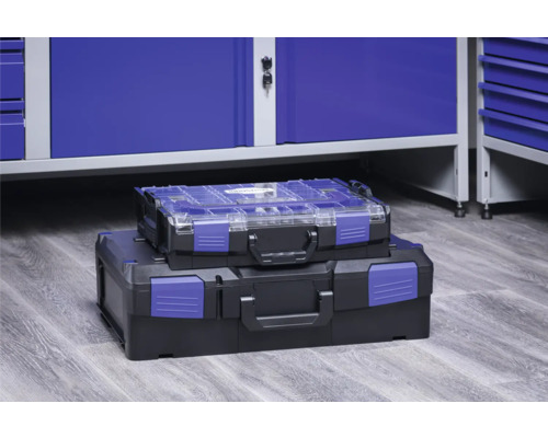 Deux boîtes à outils en plastique empilées devant une armoire d''atelier