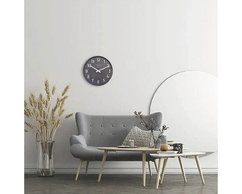 Salon avec canapé gris, tables basses, horloge murale et décoration