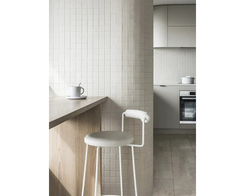 Cuisine claire avec mosaïque, tabouret de bar et plan de travail en bois