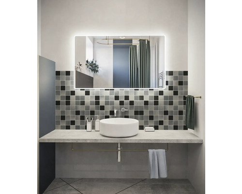 Badezimmer mit Waschtisch, Spiegel mit Beleuchtung und quadratischen Fliesen