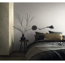 Schlafzimmer mit Bett, Wandleuchte und Dekoration