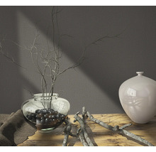 Arrangement décoratif avec vase, branches et boules décoratives sur une table en bois