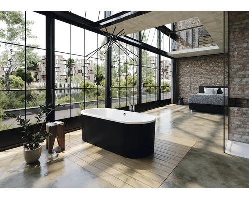 Salle de bains lumineuse de type loft avec baignoire îlot, grande fenêtre et mur en briques