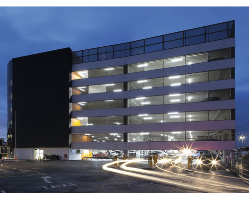 Parking à plusieurs étages avec plusieurs voitures garées.