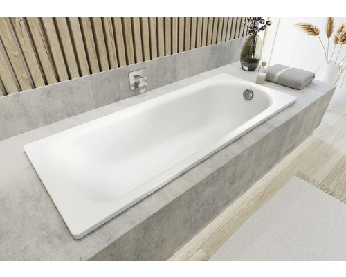 Eingebaute Badewanne im Badezimmer mit Armatur und Badaccessoires auf dem Wannenrand