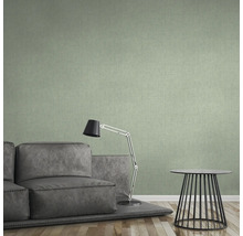 Wohnzimmer mit grüner Textiltapete, Sofa, Lampe und Tisch