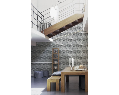 Wohnraum mit Esstisch, Sitzbank, Regal und gemusterter Tapete in Steinoptik.