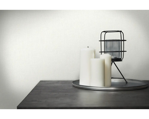 Dekorative Szene mit weißer Textiltapete, Kerzen und einer Laterne