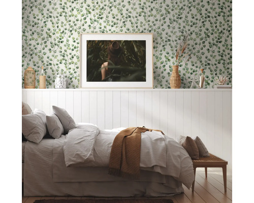 Schlafzimmer mit Tapete mit Eukalyptusmuster, Bett und Dekorationsgegenständen