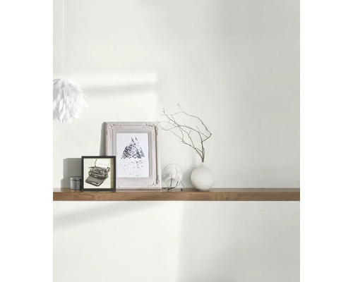 Étagère murale avec décoration : lampe, cadres photo, ventilateur et vase avec des branches