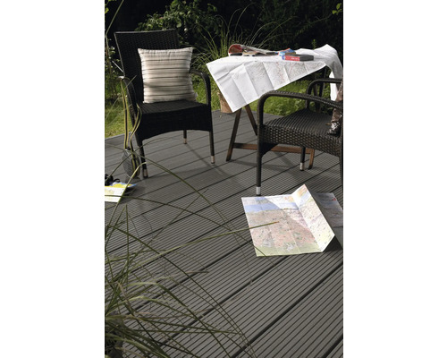 Terrasse avec lames de terrasse en composite bois-plastique, table de jardin et fauteuils en rotin