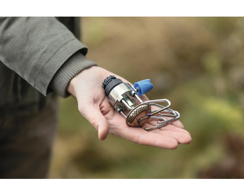 Person hält einen Campingkocher in der Hand.