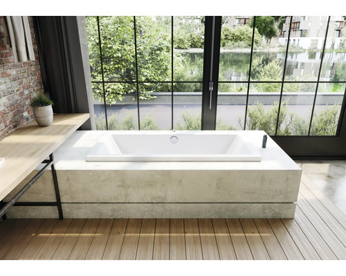 Baignoire îlot dans une salle de bains lumineuse avec vue sur un lac